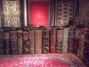 A showroom displaying numerous rolled and hanging oriental rugs, showcasing the selection at Brandon Oriental Rugs in Furlong, PA.
