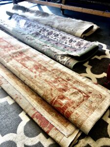 Several rolled-up area rugs, likely awaiting or after cleaning, handled by Celtic Carpet Cleaner in Fort Lauderdale, FL.