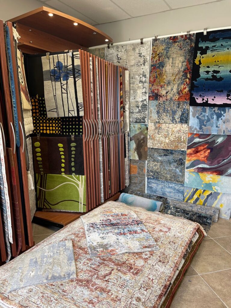 Rolled rugs and hanging samples showcasing options at Rugs By Design, a carpet contractor in Castleton, IN.