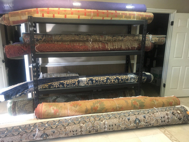 Various rolled rugs neatly stored on shelves, ready for service or delivery by Rug Renew in Spring Valley, CA.