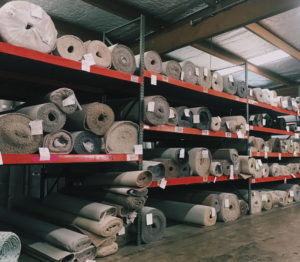Large rolls of various carpets stored in the warehouse at The Carpet & Decorating Center in Phenix City, AL.
