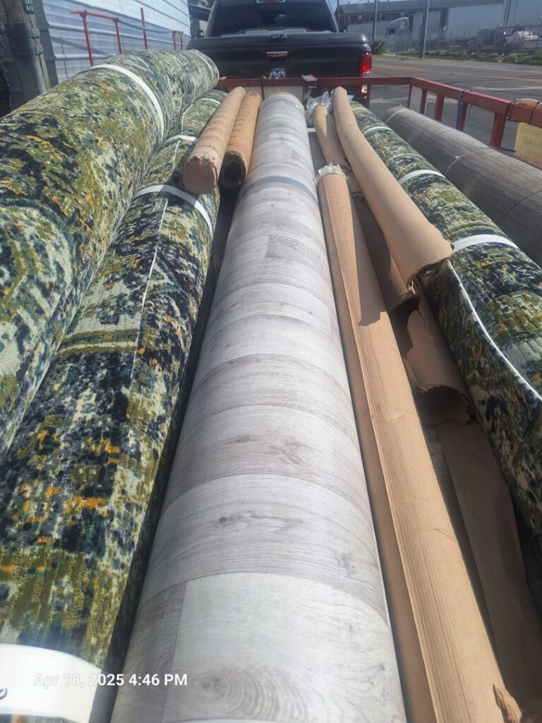 Various rolls of carpet and vinyl flooring loaded on a truck by AFAB Carpets in Tampa, FL.