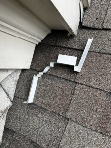 A piece of metal roof flashing or vent cover, used for wildlife exclusion, on a roof by Defense Pest and Wildlife Control in Hartford, CT.