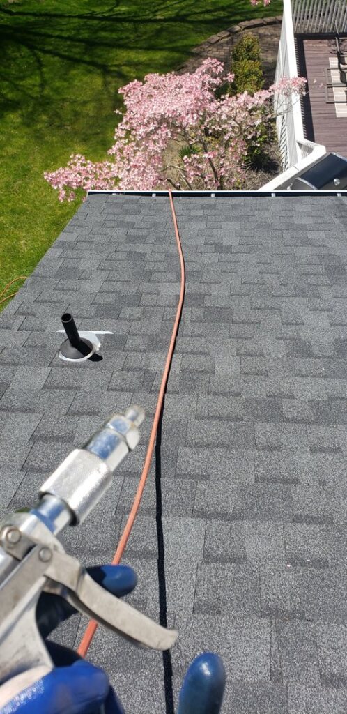 A pest control sprayer being used on a residential roof for treatment by Serene Property Services LLC in Albany, NY