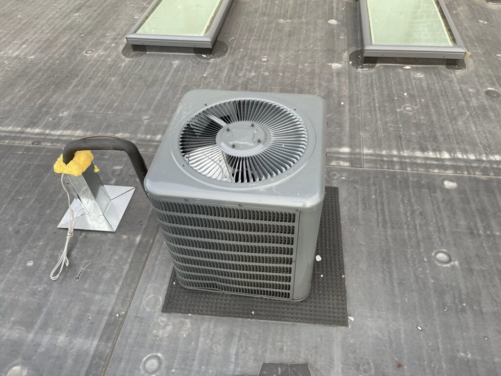 An outdoor AC condenser unit installed on a rooftop by Best Plumbing Heating & Cooling Contractors in Albany, NY.