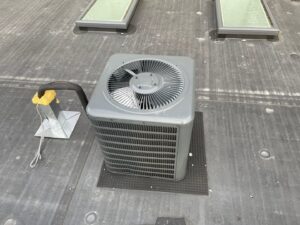 An outdoor AC condenser unit installed on a rooftop by Best Plumbing Heating & Cooling Contractors in Albany, NY.