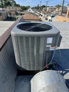 An outdoor AC condenser unit on a rooftop, serviced by Four Stages, an HVAC contractor in Chicago, IL.