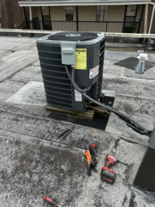 A rooftop AC condenser unit with tools nearby, indicating an HVAC service job by 511Comfort, LLC in Nashville, TN.