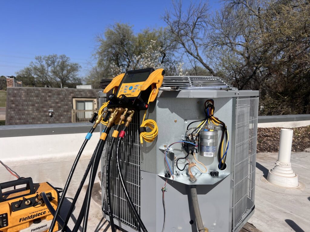 A rooftop AC unit with Fieldpiece diagnostic tools connected during a service call by Jupitair in Frisco, TX.