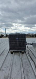 A rooftop AC unit installed on a metal roof by Pike Mechanical in Vevay, IN.