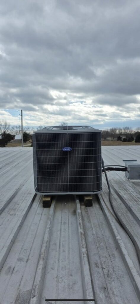 A rooftop AC unit installed on a metal roof by Pike Mechanical in Vevay, IN.
