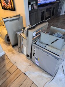 A technician on a roof overseeing the removal of an old AC unit by a crane, performed by ASAP Air Conditioning and Heating in Mesa, AZ.