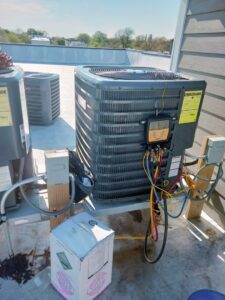 A rooftop air conditioning unit being serviced with diagnostic tools by Bean'z Heating and Cooling in Chicago, IL.