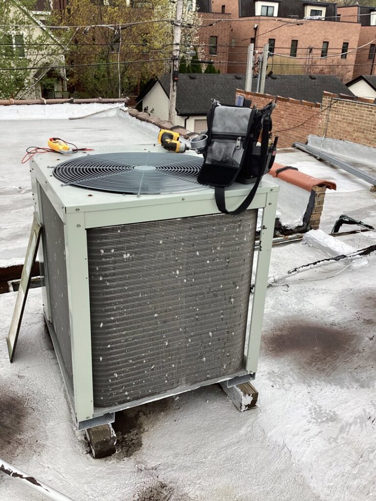 A rooftop air conditioning unit with tools on top, indicating ongoing service by Service Champions Heating & Cooling in Aurora, IL.