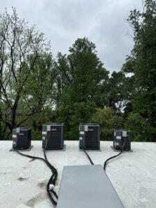 Four outdoor air conditioning units installed on a rooftop by Brothers HVAC LLC in Owings Mills, MD