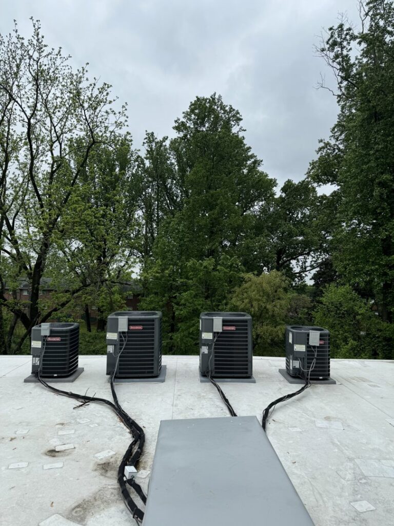 Four outdoor air conditioning units installed on a rooftop by Brothers HVAC LLC in Owings Mills, MD