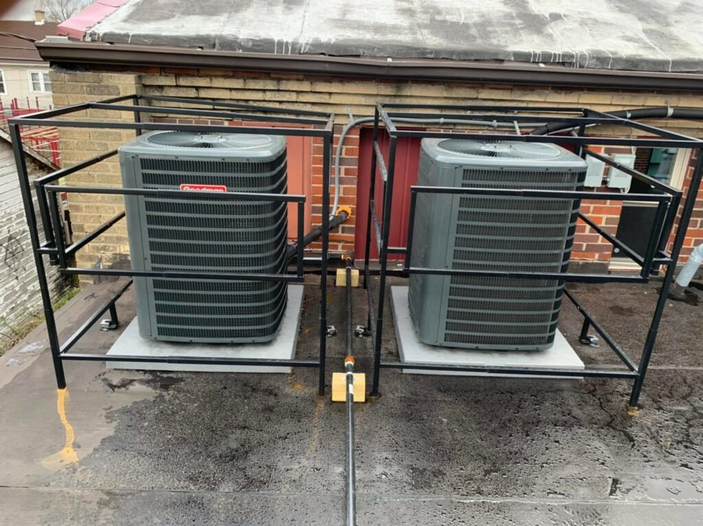Two Goodman outdoor air conditioning units installed on a rooftop by Detroit Metro Mechanical, Inc. in Harrison Township, MI.