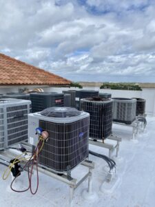 Multiple rooftop AC units, with one being serviced by T&D Air Conditioning in Fort Lauderdale, FL.