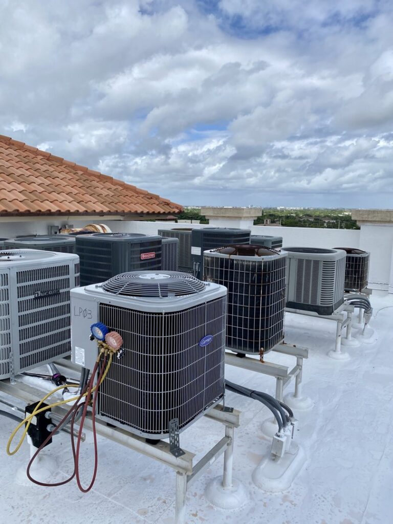 Multiple rooftop AC units, with one being serviced by T&D Air Conditioning in Fort Lauderdale, FL.