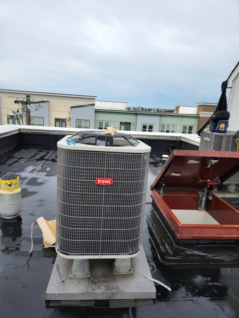 A Bryant HVAC unit on a commercial rooftop, undergoing service by ECA DuctWorks in Reston, VA