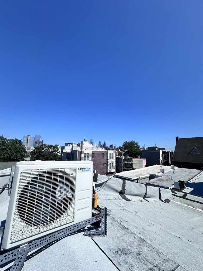 A ComfortStar mini-split unit installed on a rooftop with the Philadelphia skyline in the background by Mueller Mechanical HVAC.