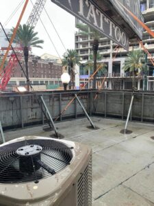 An outdoor commercial air conditioning unit installed on a rooftop with a city skyline in the background by Get RiTe A/C & Heating in Madisonville, LA.