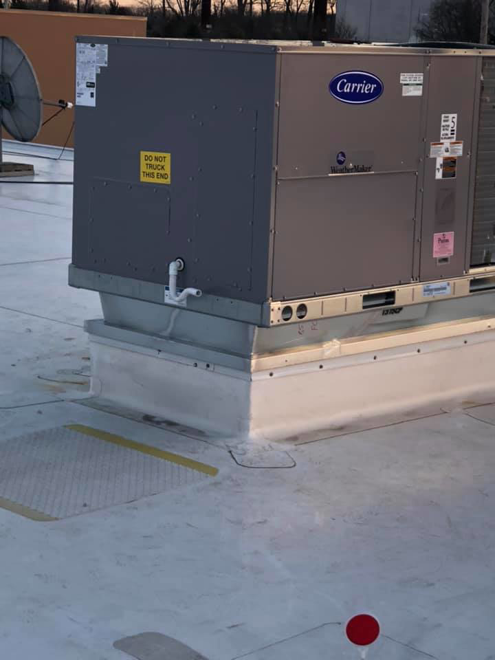 A large Carrier WeatherMaker commercial HVAC system installed on a building rooftop by Air Quality, LLC in Cranston, RI
