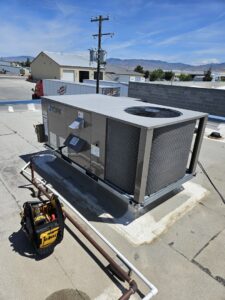A rooftop commercial HVAC unit with a toolbox nearby, indicating service by ABC Mechanical Inc in Lawrenceville, GA.