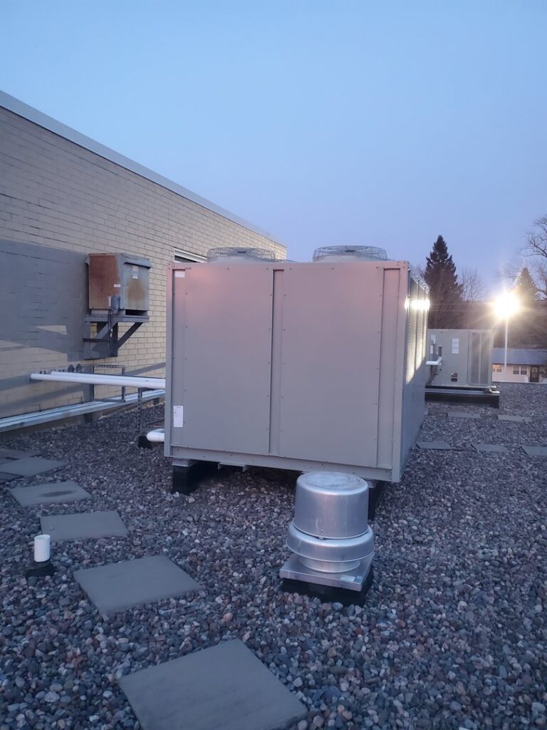 A commercial rooftop HVAC unit on a gravel roof serviced by Advantage Mechanical, Inc. in Appleton, WI.
