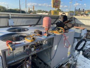 Rooftop commercial HVAC unit with tools and diagnostic equipment during service by Benavidez Heating & Air Conditioning In, Arlington, TX.