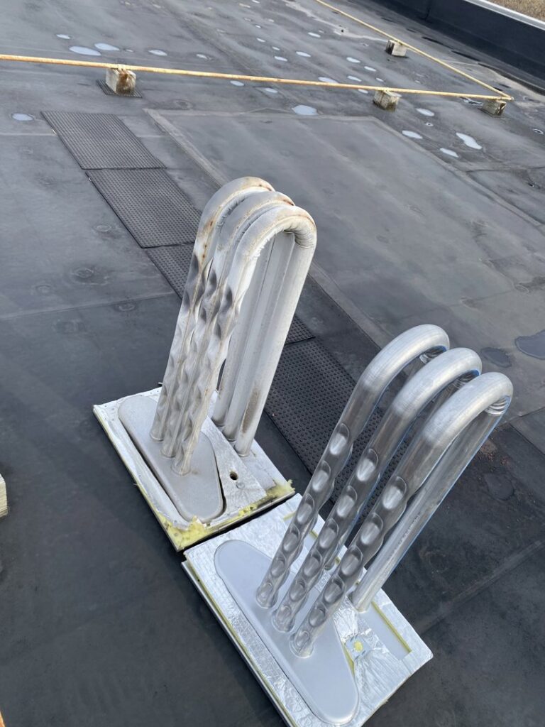 Large rooftop HVAC coils, likely part of a commercial system, serviced by Service Champions Heating & Cooling in Aurora, IL.