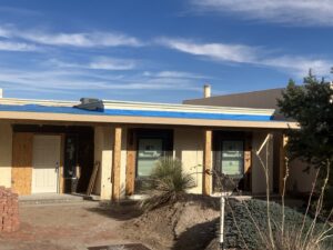 An outdoor HVAC condenser unit visible on the roof of a house by Home Repair Contractors in Las Cruces, NM