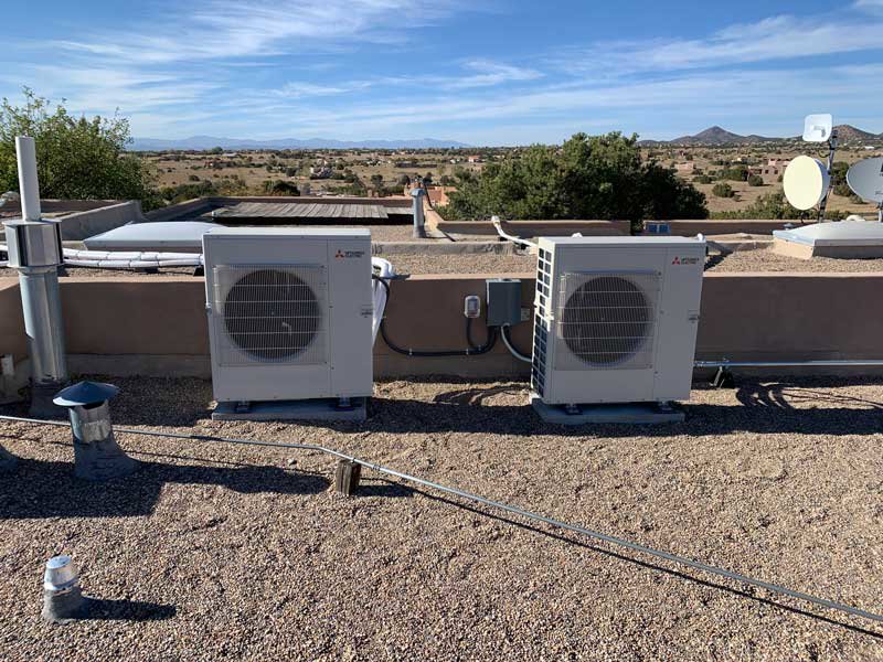 Two outdoor HVAC condenser units installed on a rooftop by Jerome's Mechanical, LLC in Santa Fe, NM