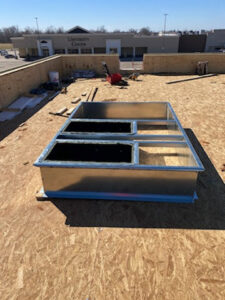 A metal rooftop HVAC curb installed on a commercial building roof deck by Dowd Heat & Air in Tulsa, OK.