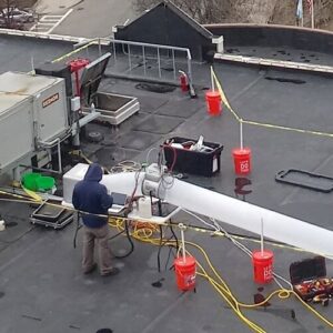 A technician performing rooftop HVAC duct sealing and testing for Aspen Air Duct Cleaning in Methuen, MA.