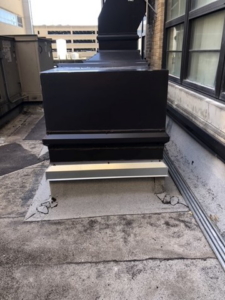 Rooftop HVAC ductwork base with a large rectangular component and vertical stack by Kuhlmann Supply Company in Earth City, MO