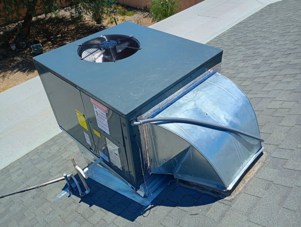 A newly installed Goodman rooftop HVAC package unit with ductwork on a residential roof by Krahn and Son Mechanical in Glendale, AZ.