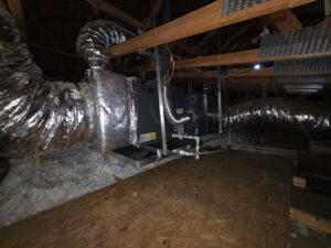 A Goodman rooftop HVAC package unit installed on a metal stand on a residential shingle roof by Krahn and Son Mechanical in Glendale, AZ.