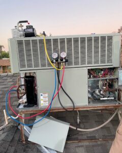 A rooftop HVAC package unit being serviced with gauges connected by Kaluas HVAC Mechanical Services in Phoenix, AZ