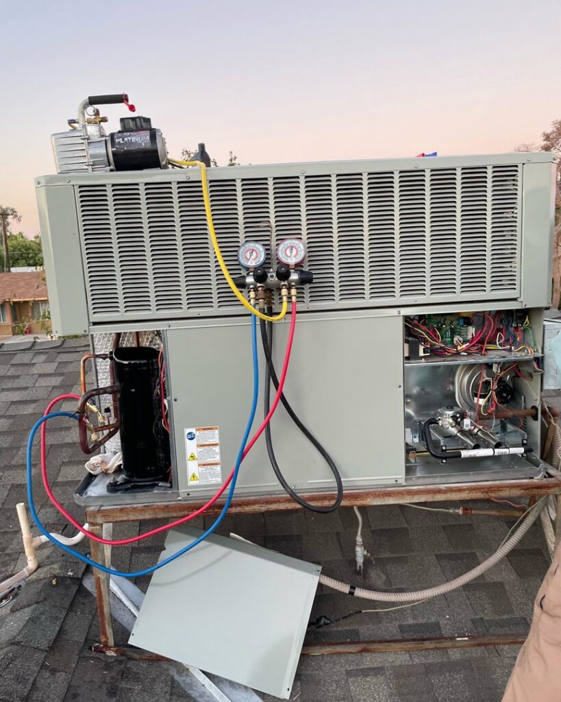 A rooftop HVAC package unit being serviced with gauges connected by Kaluas HVAC Mechanical Services in Phoenix, AZ