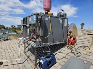 A rooftop HVAC system undergoing maintenance with gauges and tools connected by Tanana Air Conditioning & Heating in Las Vegas, NV.