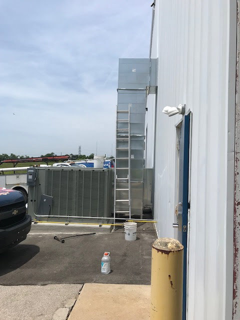 A commercial rooftop HVAC unit being lifted by a crane for installation by Ware's Heating & Cooling in Georgetown, KY.