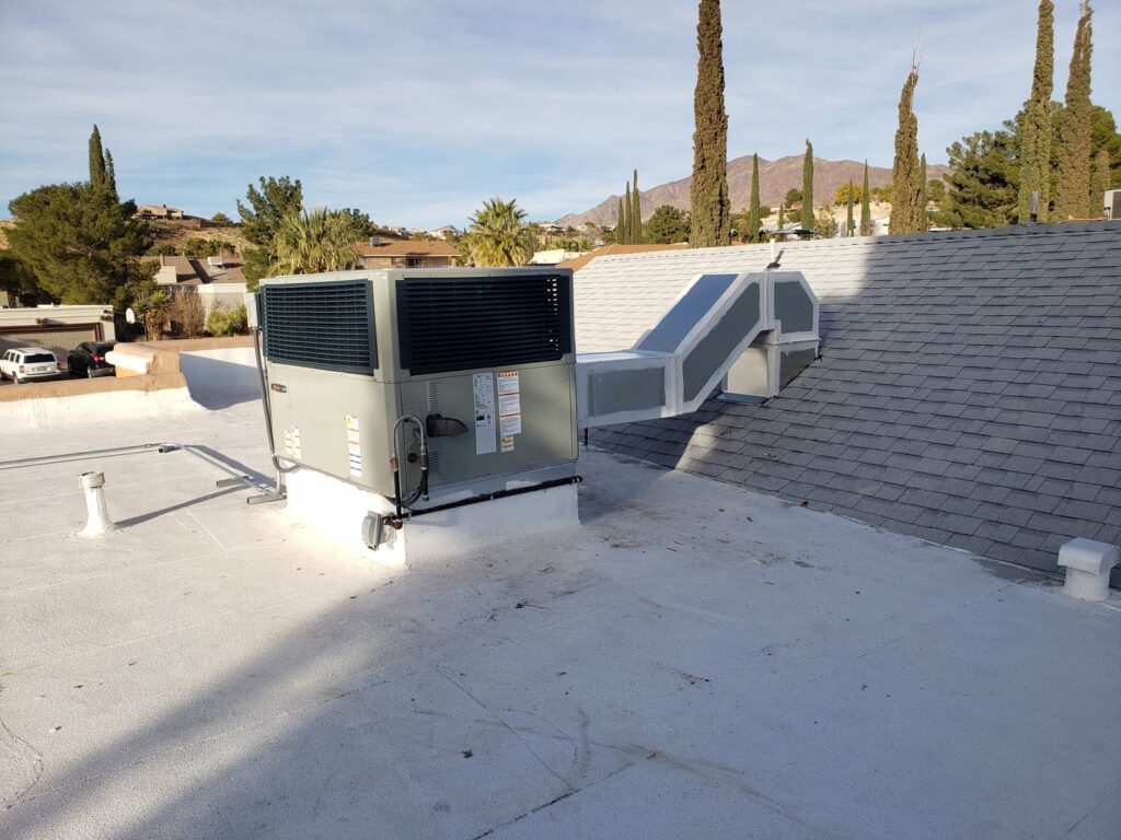 A rooftop HVAC unit with ductwork installed on a building by Dynamic Heating, Cooling, Refrigeration & Roofing in El Paso, TX.