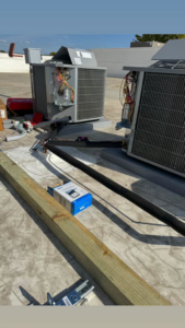 A rooftop HVAC unit with its electrical panel open, showing wiring, indicating work by Redmond Electric LLC in Horn Lake, MS.
