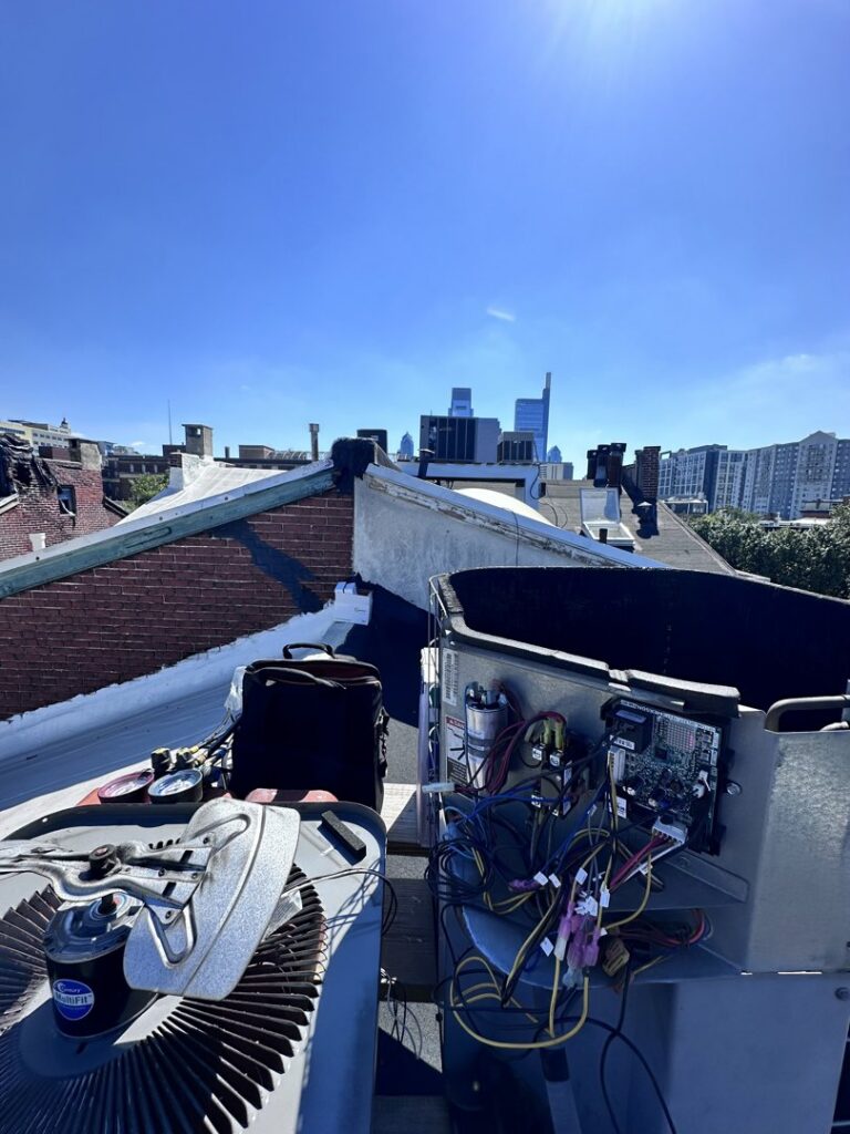 An outdoor rooftop HVAC unit with its electrical panel open for repair by Mueller Mechanical HVAC in Philadelphia, PA.