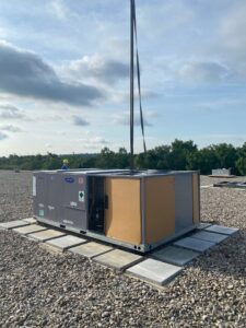 A rooftop HVAC unit being installed with a crane by Cafco Services in Cincinnati, OH.
