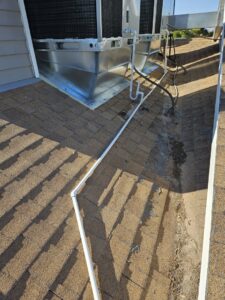 Detailed view of a rooftop HVAC unit installation with piping on a shingle roof by Colton Air Conditioning - Las Vegas in Las Vegas, NV.
