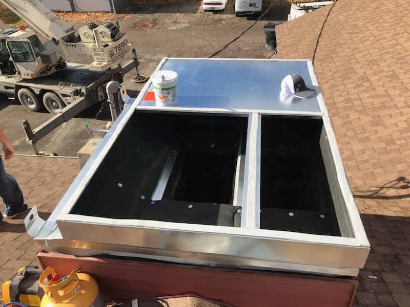 A commercial rooftop HVAC unit being installed with a crane in the background by Element Heating & Cooling, Inc. in Twin Falls, ID