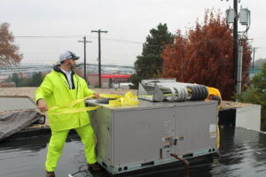 An HVAC technician preparing a large rooftop unit for installation or removal by RSC Heating and Air Conditioning in Lancaster, PA.