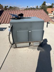 A rooftop HVAC unit installed by Usa Air Conditioning & Heating, with a technician's shadow, in Las Vegas, NV